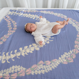 Baby lying on a decorative bedspread with floral patterns