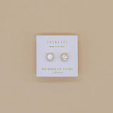 Pair of mother of pearl earrings with gold facets on a Jax Kelly branded card 