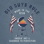 T-shirt with 'Old Guys Rule' graphic design featuring a barbecue and American flags on a blue background.