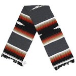 Striped blanket with black, red, beige, and white colors on a white background
