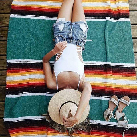 Person lying on a colorful striped towel 