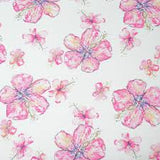 A quilt with a floral pattern featuring hibiscus flowers in shades of pink, yellow, and blue.